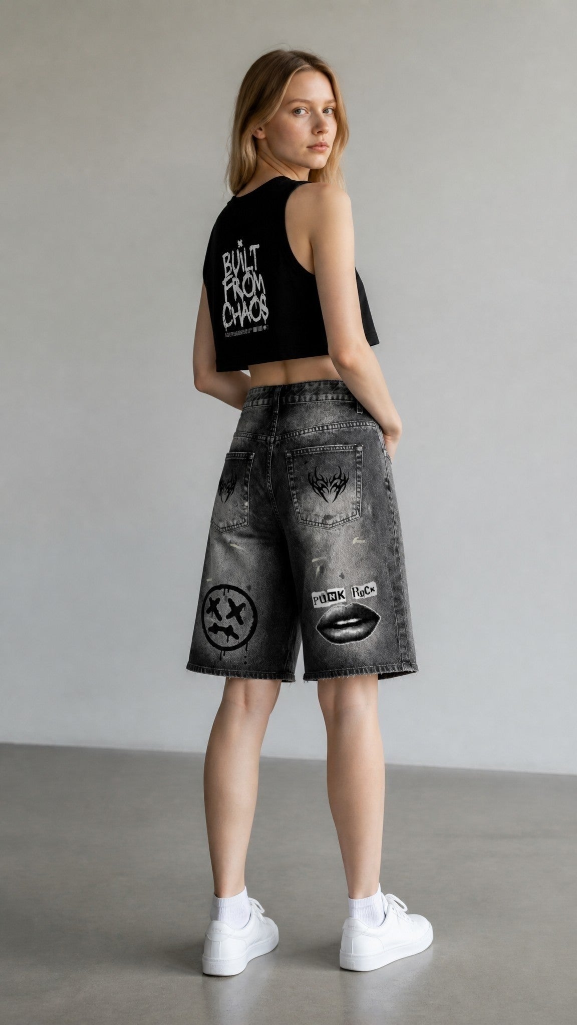 ALTRD Apparel black cropped crewneck tank top with graphic print worn by a model with distressed denim shorts