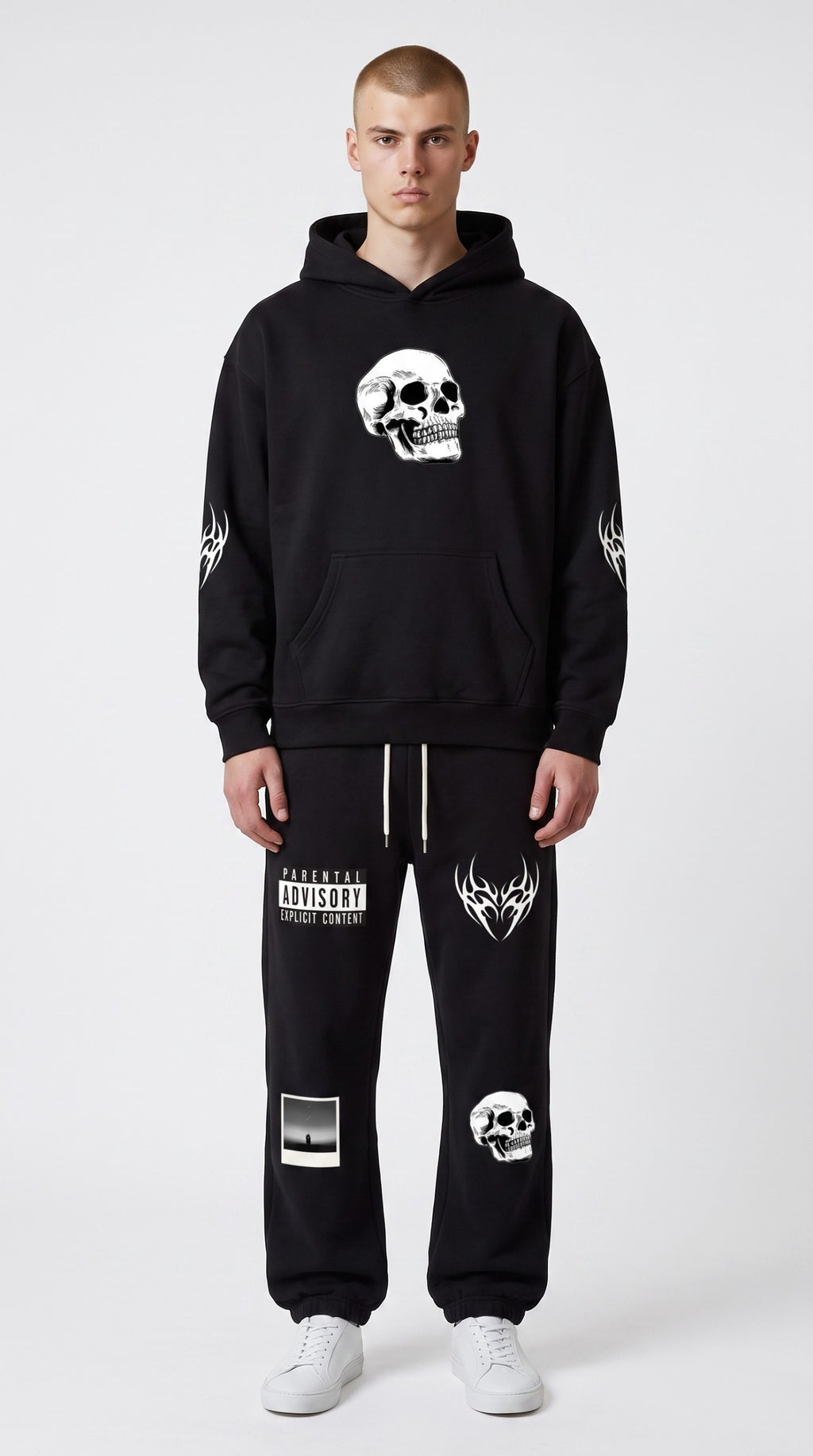 ALTRD Apparel oversized black fleece hoodie with white skull graphic and tribal sleeve prints worn by a male model.