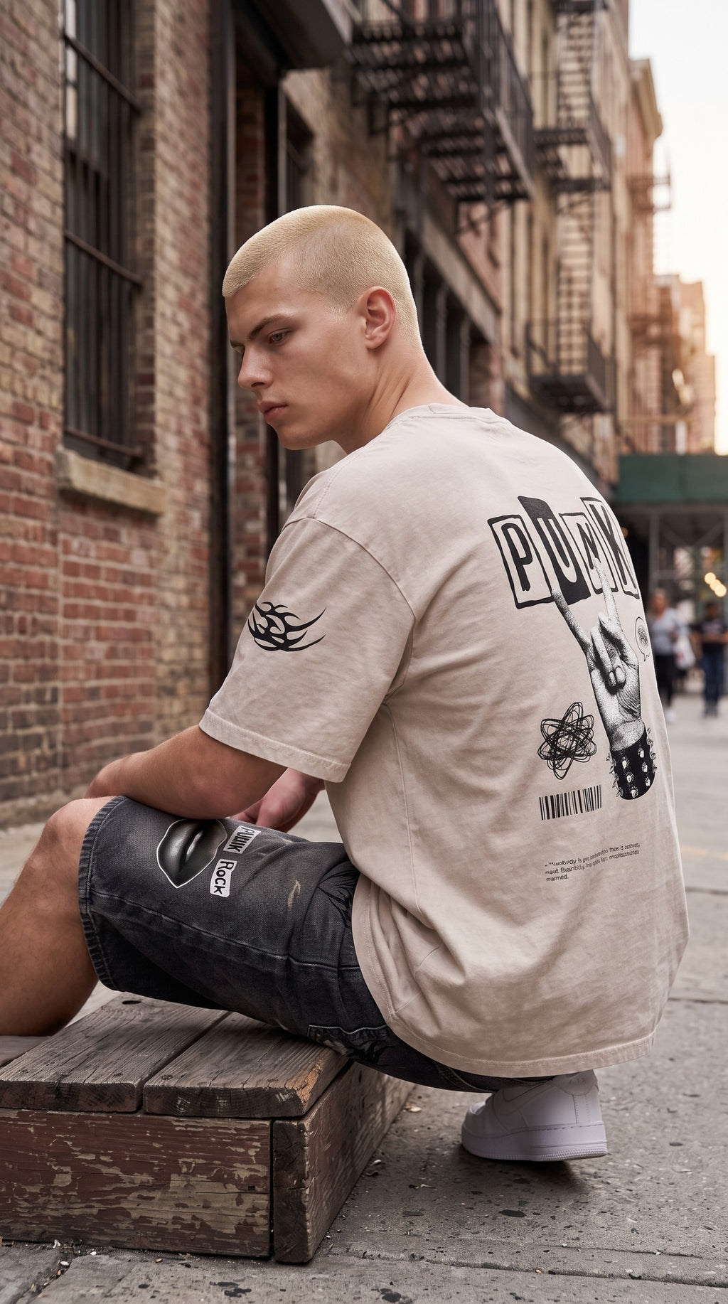 ALTRD Apparel oversized beige snow-washed cotton t-shirt with punk-inspired back graphic worn by a model outdoors