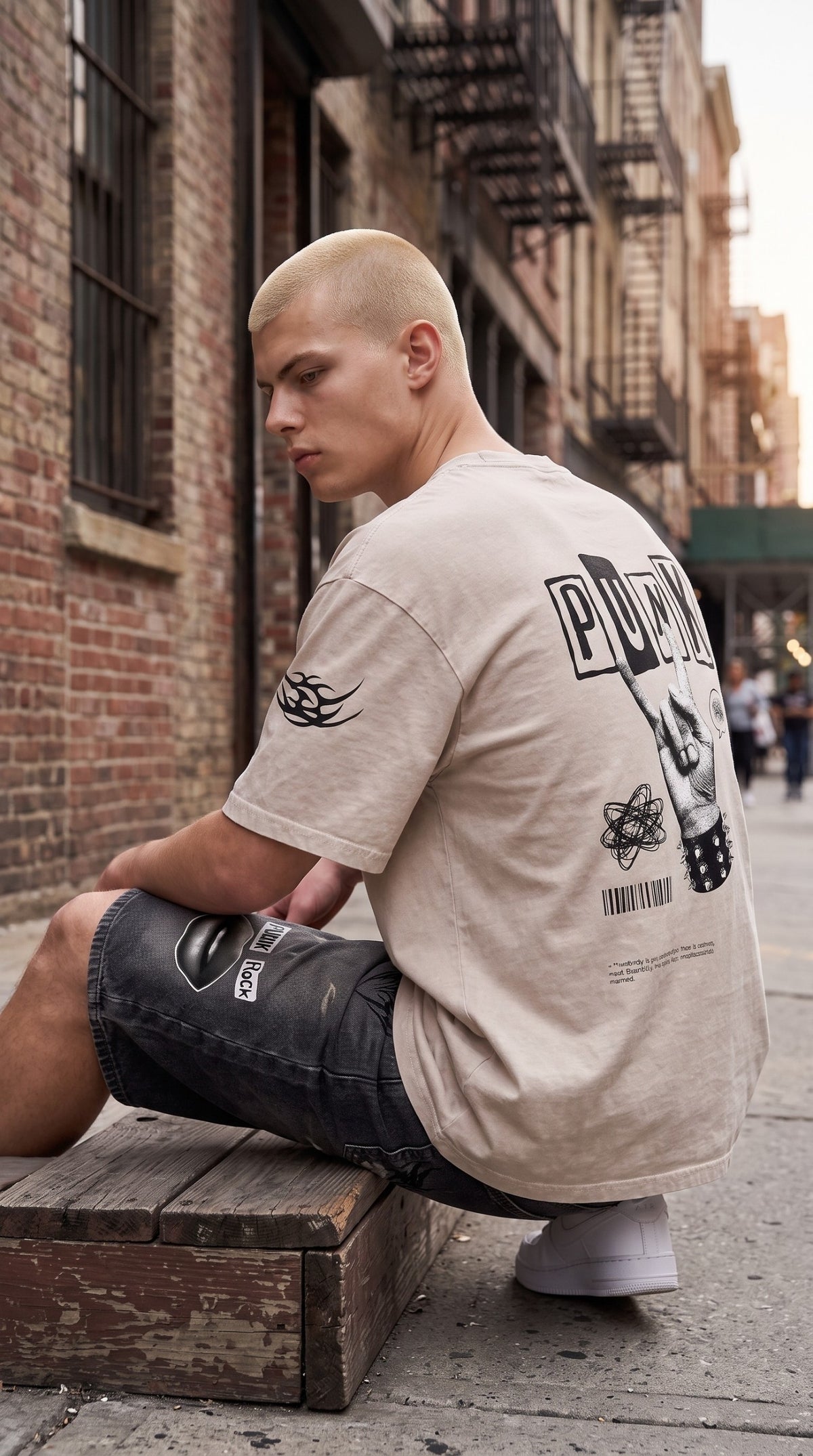ALTRD Apparel oversized beige snow-washed cotton t-shirt with punk-inspired back graphic worn by a model outdoors
