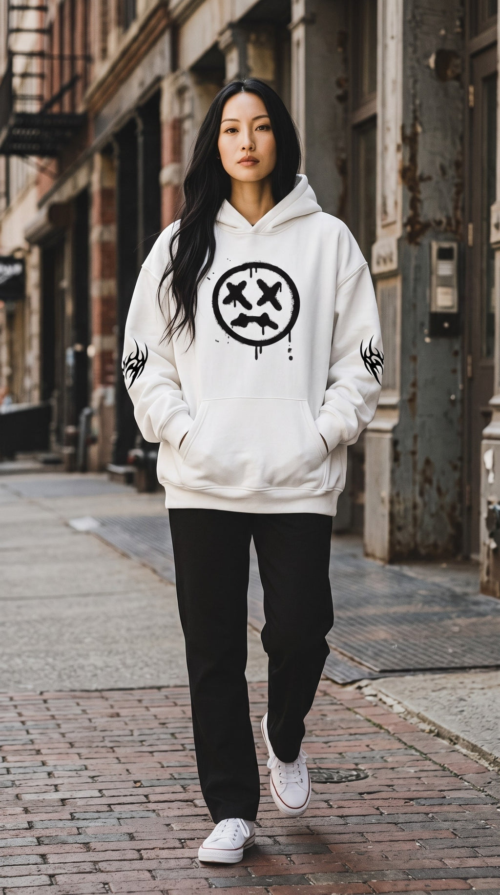 Model wearing an ALTRD Apparel white oversized fleece hoodie with a black graphic print on a city street.