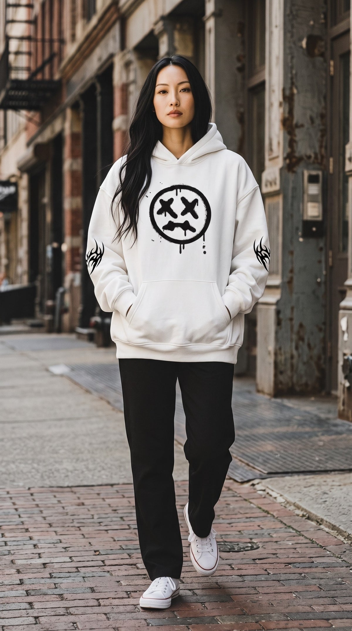 Model wearing an ALTRD Apparel white oversized fleece hoodie with a black graphic print on a city street.